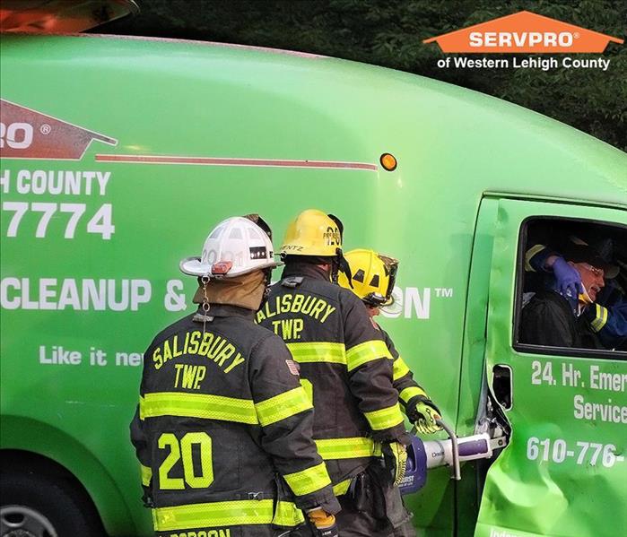 Fire fighters cutting into a vehicle to save a person.