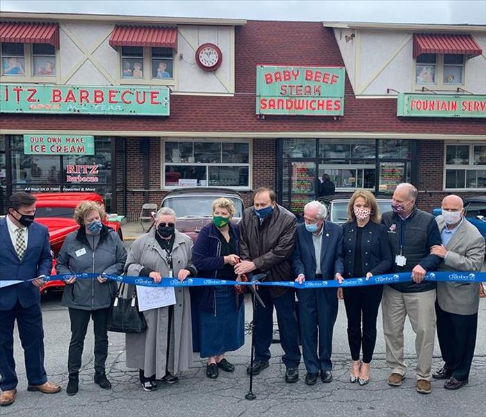 The Chamber of Commerce members cutting the ribbon for a reopening!